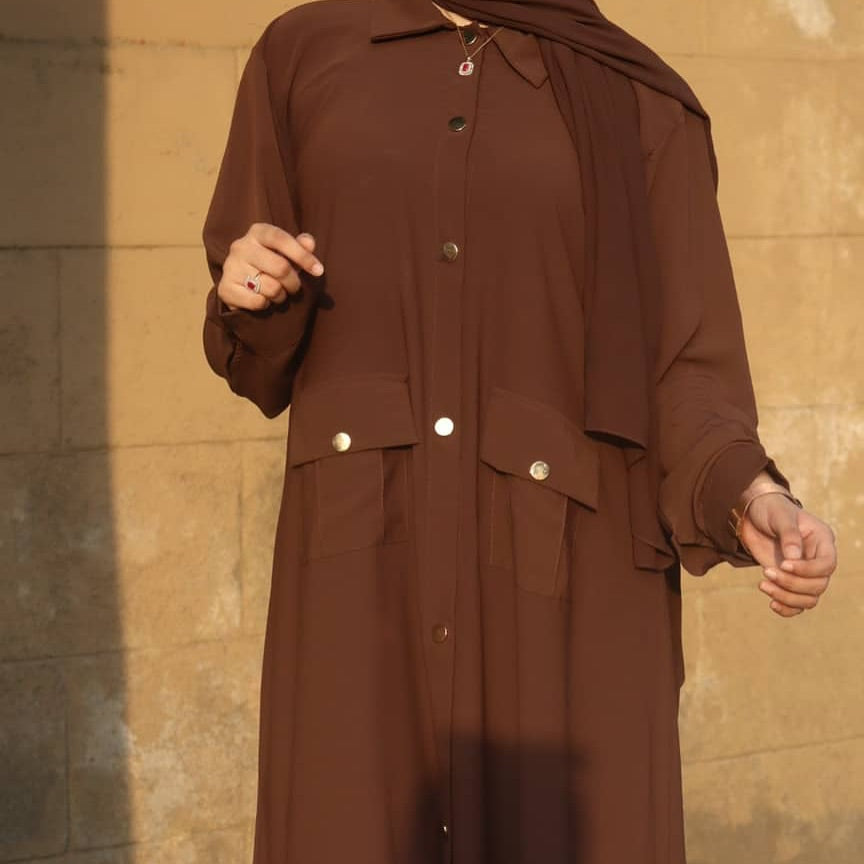 Close-up of flap pockets with button detailing on shirt abaya