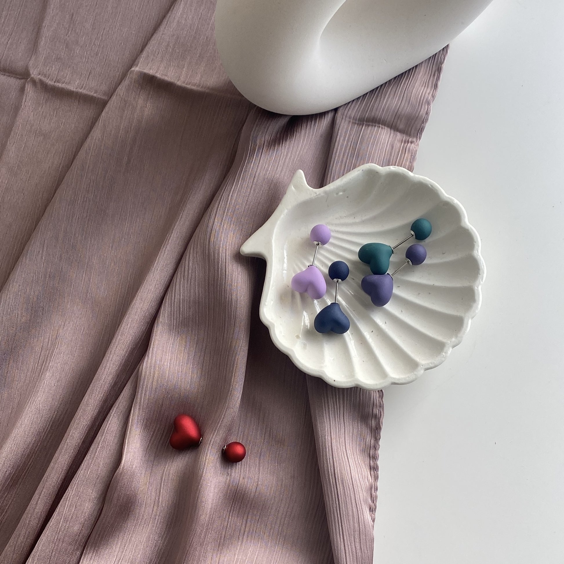 Assorted heart-shaped hijab pins on display dish – Hijabaa