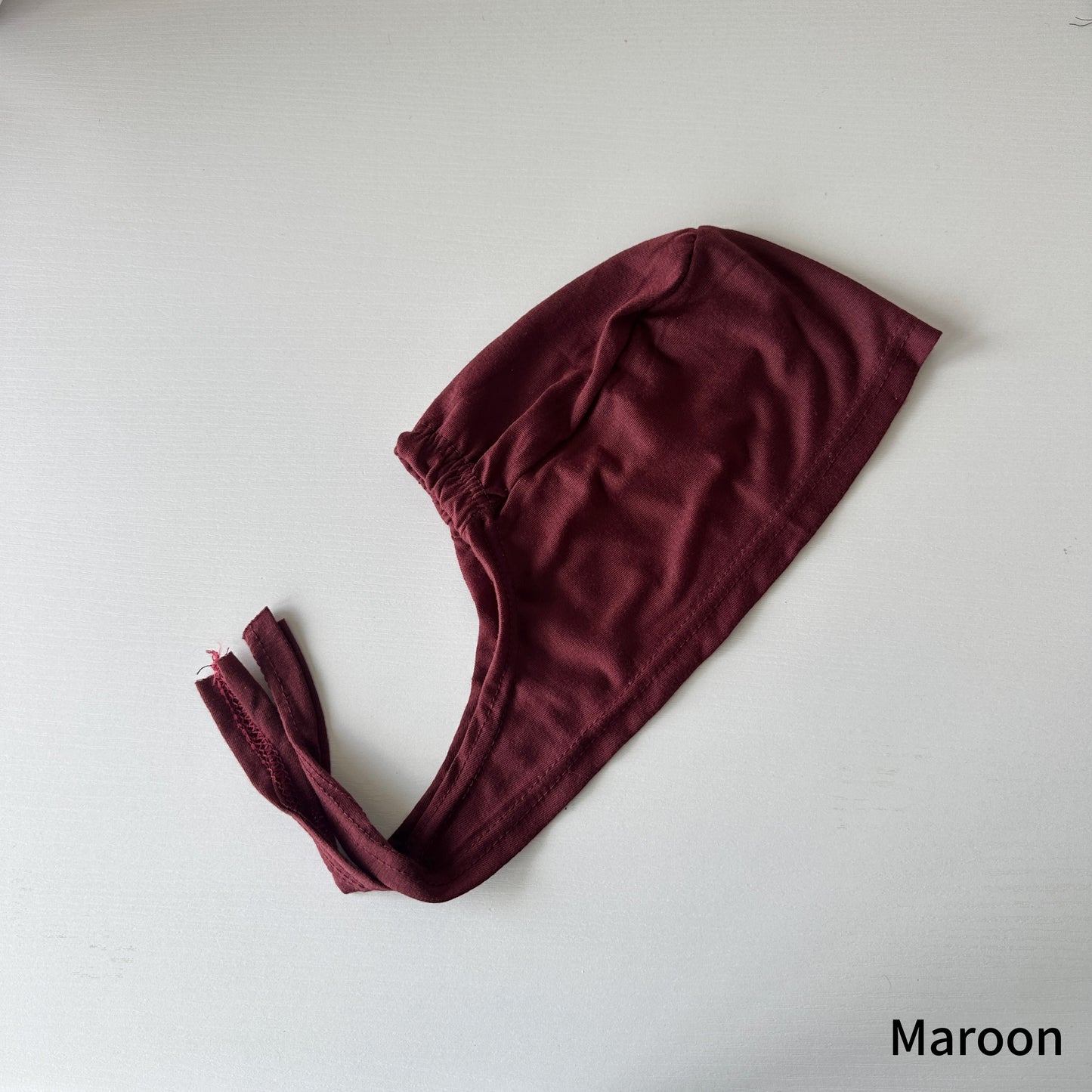 Side view of model in tie cap under a chiffon hijab