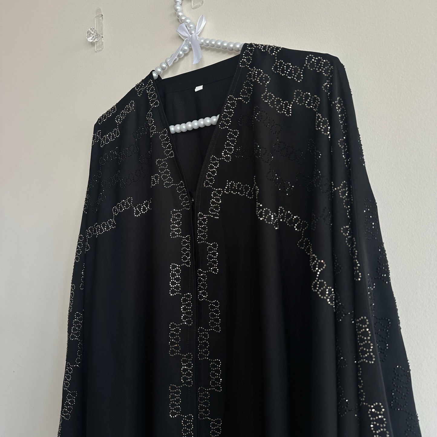 Side view of Noir Abaya showing elegant drape and shine – Hijabaan NZ