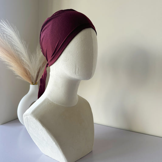 Model wearing a black tie-back hijab cap – cotton polyester blend